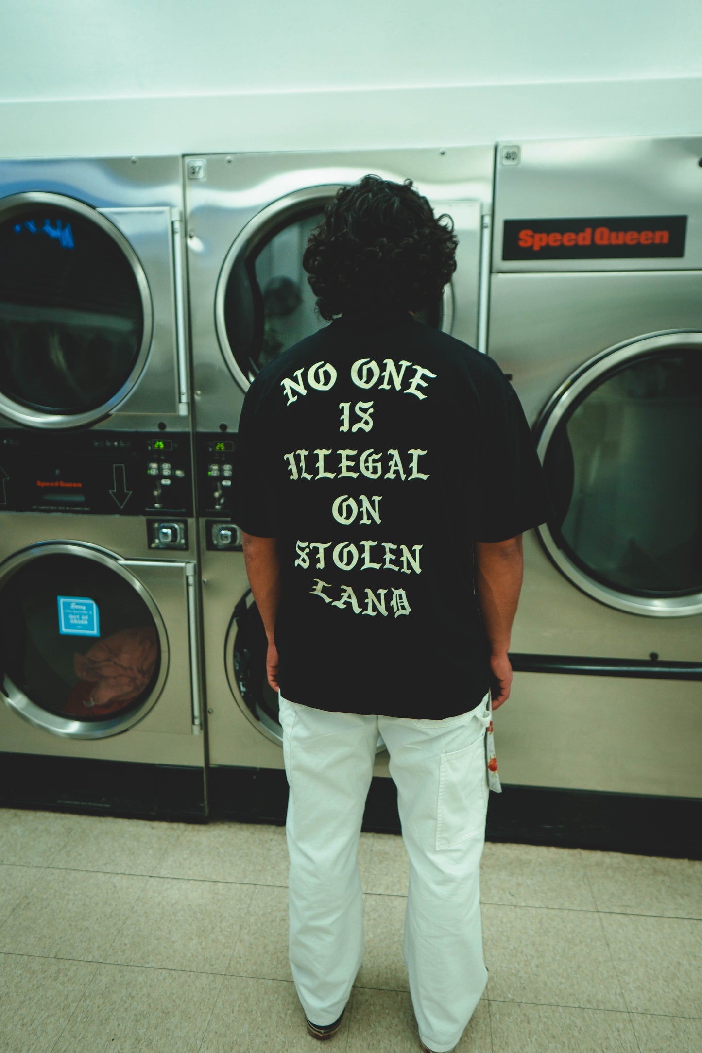 NO ONE IS ILLEGAL ON STOLEN LAND TEE: NEGRO